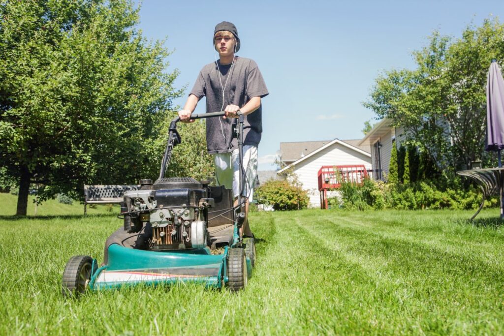 a teenage boy cutting grass